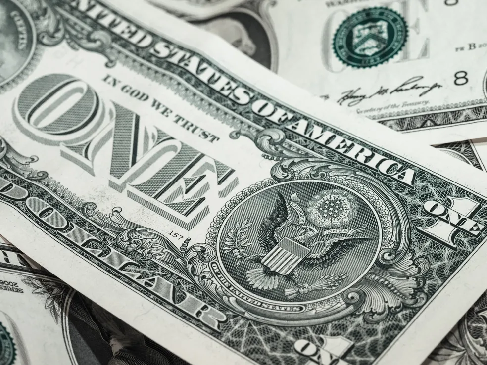 Dólar opera em baixa, após queda nas projeções para inflação e com dados dos EUA no radar